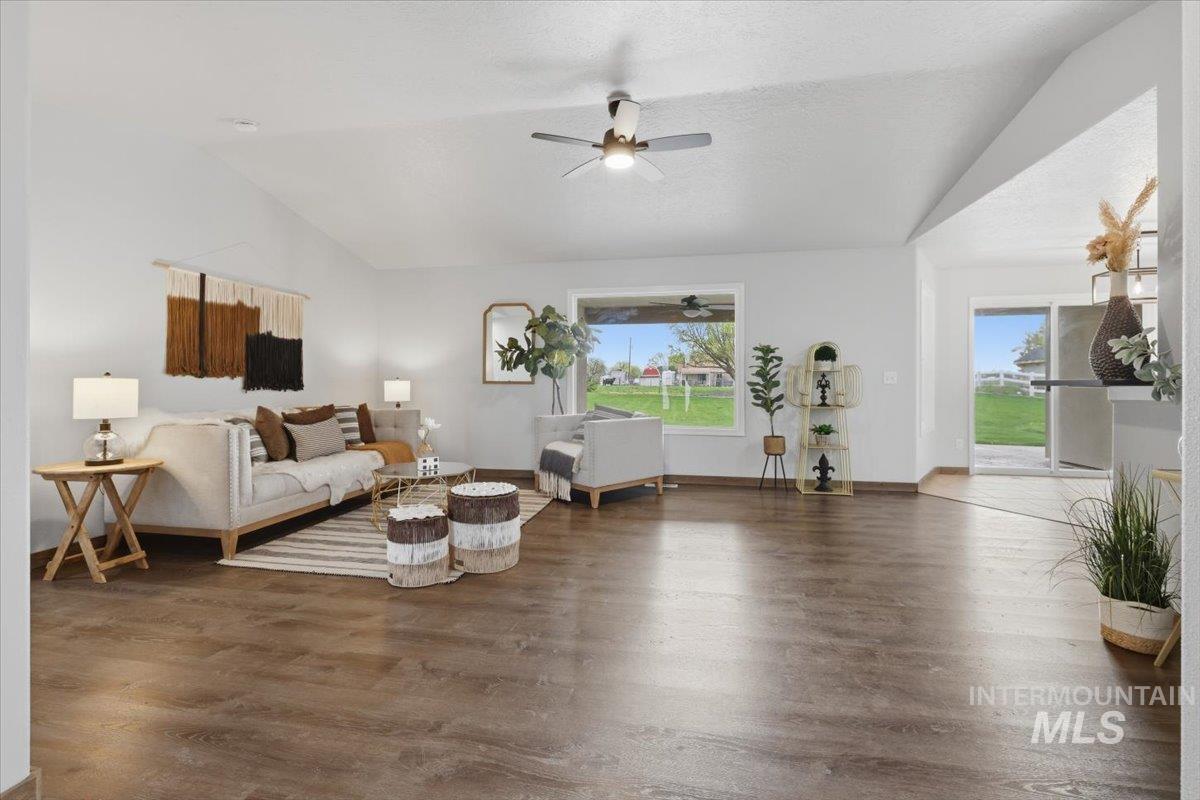 25022 Tumbleweed Road Middleton, ID 83644 - Photo 8 of 41 Living room with dark wood-style floors, a ceiling fan, and vaulted ceiling