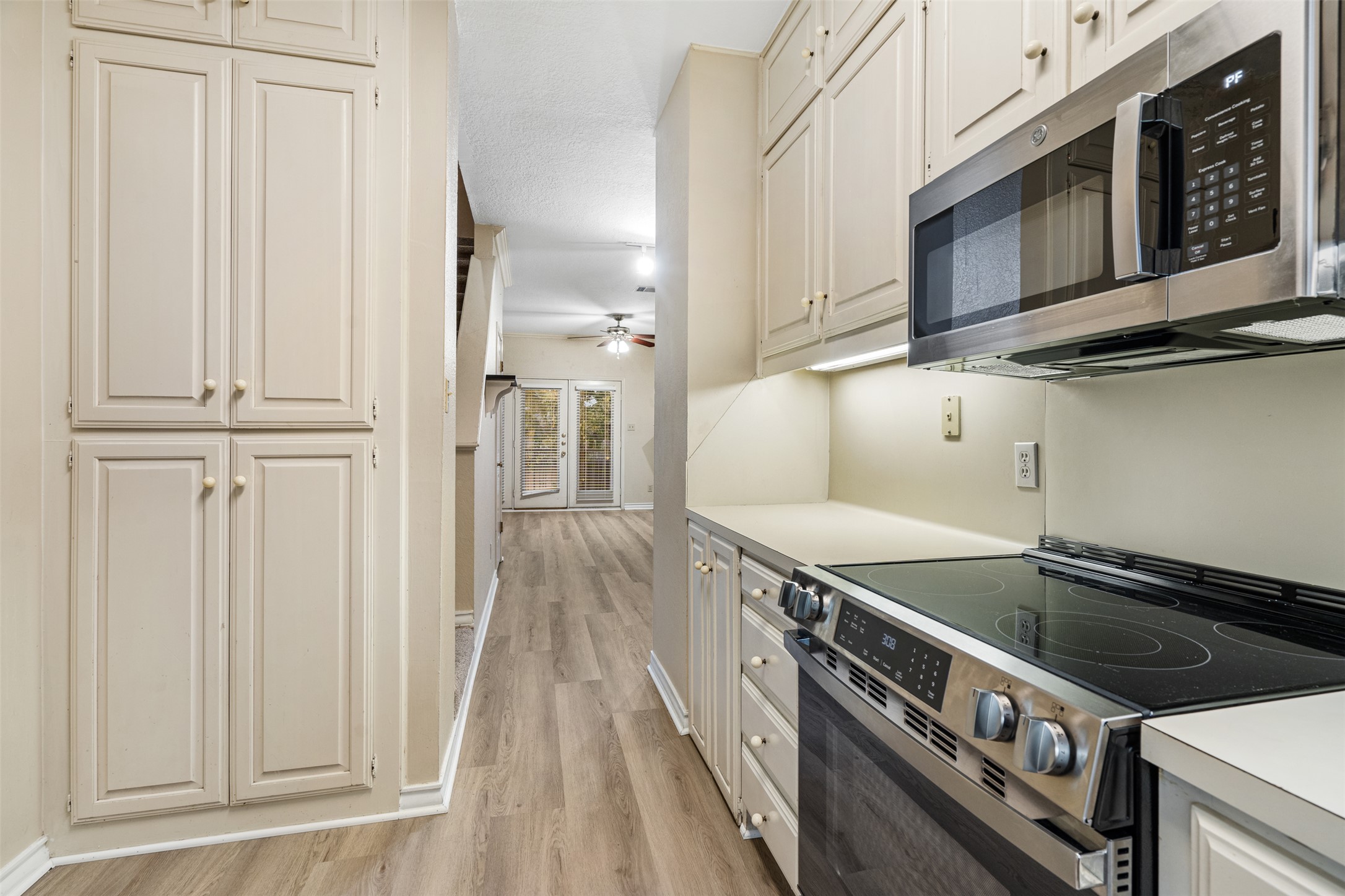 2408 Enfield Road, Unit 211 Austin, TX 78703 - Photo 12 of 26 Kitchen with appliances with stainless steel finishes, light countertops, light wood-type flooring, and ceiling fan