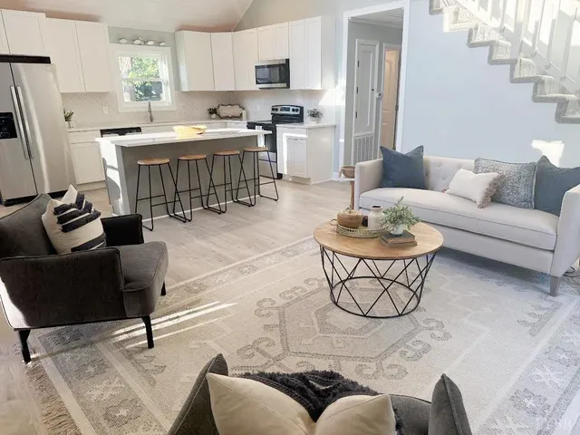 a living room with lots of furniture and kitchen view