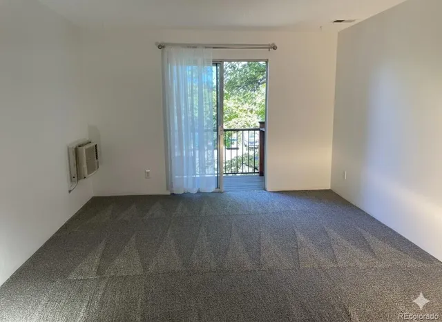 a view of a livingroom with an empty space and a window