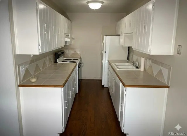 a kitchen with stainless steel appliances granite countertop a sink a stove and a refrigerator