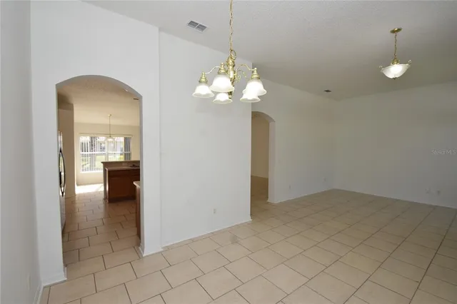 a view of a kitchen and a chandelier wooden floor and windows