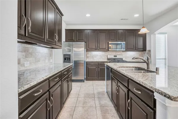 a kitchen with granite countertop cabinets stove and microwave