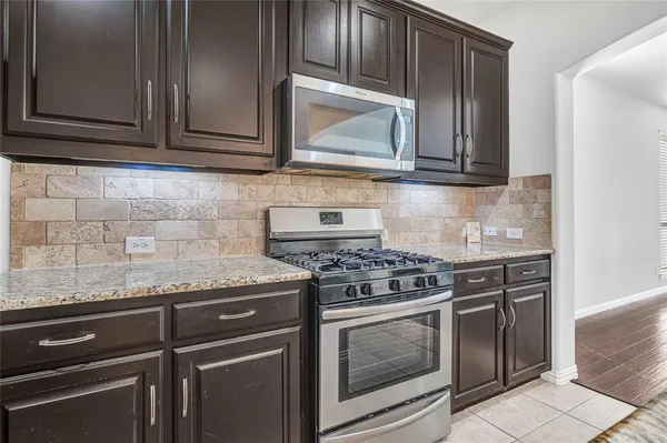 a kitchen with stainless steel appliances granite countertop a sink a stove and oven