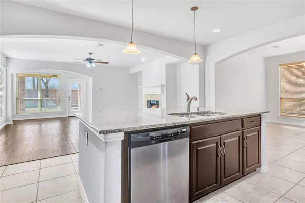 a view of kitchen with granite countertop cabinets and refrigerator