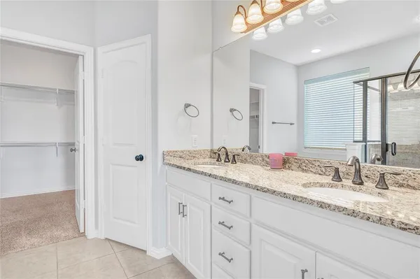 a bathroom with double sink and a mirror