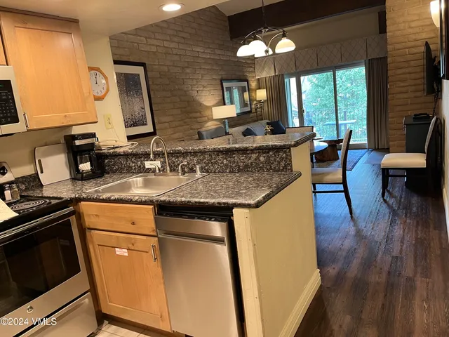 a kitchen with stainless steel appliances granite countertop a sink stove and wooden floor