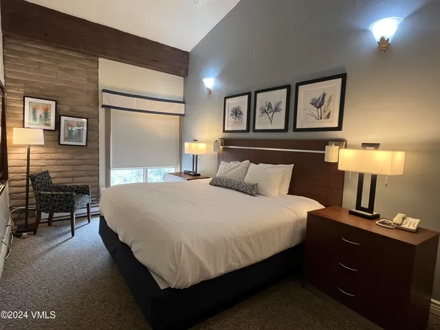 a bedroom with a bed and a lamp on table