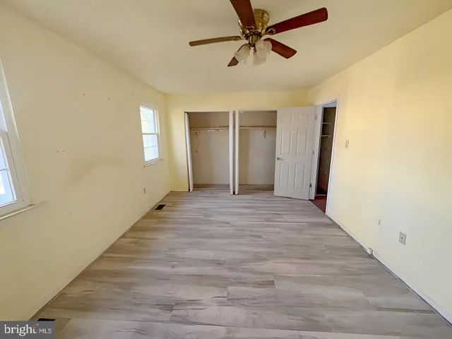 a view of a room with wooden floor and ceiling fan