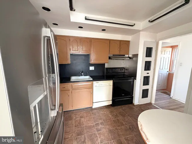 a kitchen with stainless steel appliances a refrigerator and a stove top oven