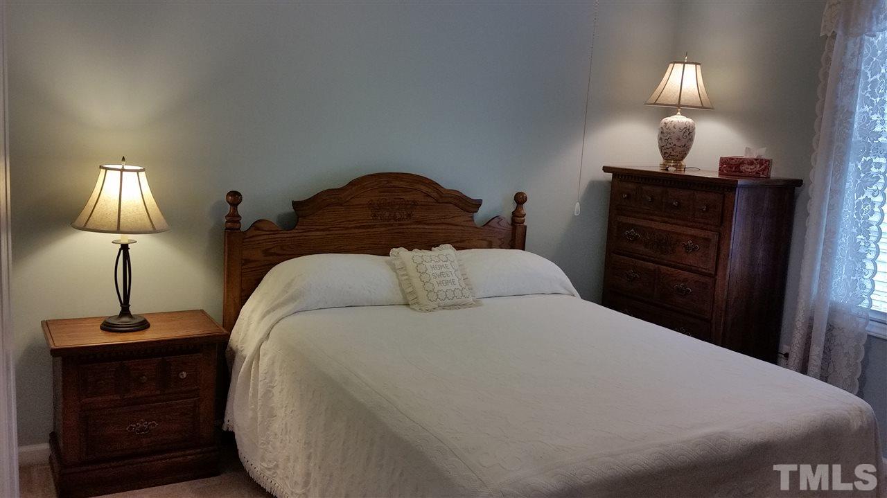 5425 Neuse Forest Road Raleigh, NC 27616 - Photo 11 of 25 a bedroom with a bed and a lamp