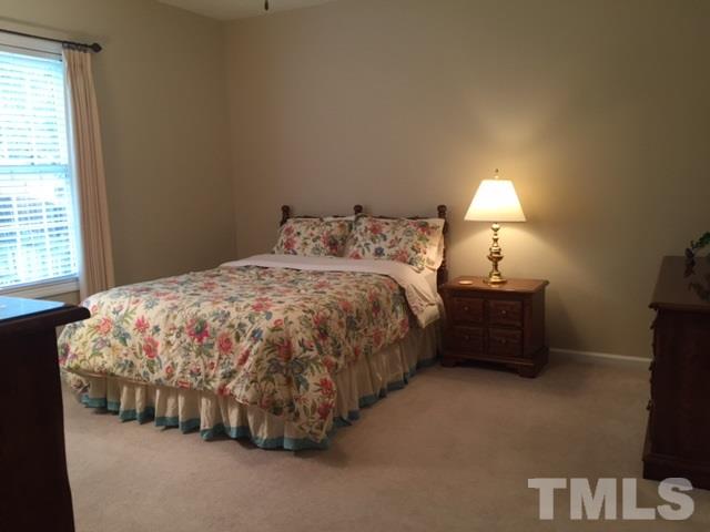 5425 Neuse Forest Road Raleigh, NC 27616 - Photo 8 of 25 a bedroom with a bed and a lamp next to a window