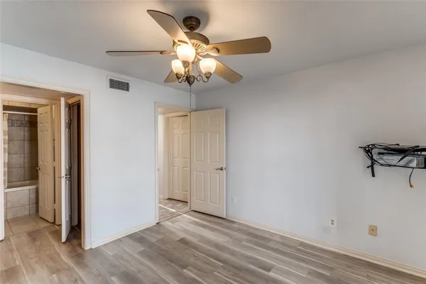 a view of a livingroom with a chandelier fan and wooden floor