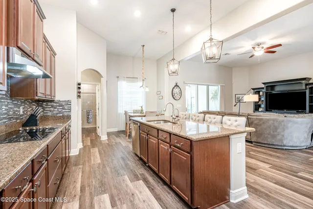 a large kitchen with granite countertop a large counter top appliances and cabinets