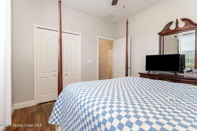 a bedroom with a bed and a flat screen tv