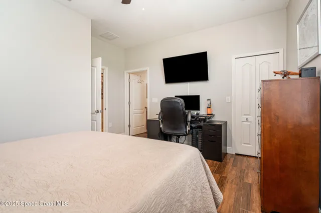 a bedroom with a bed and a flat tv screen