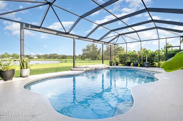 a view of a house with a big yard and palm trees
