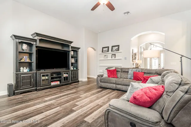 a living room with furniture and a wooden floor