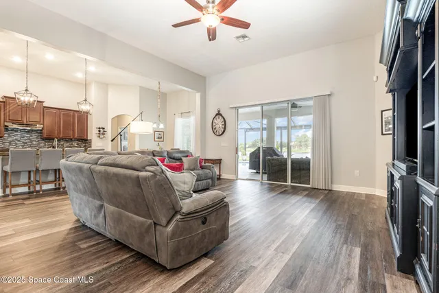 a view of a dining room with furniture a chandelier and wooden floor