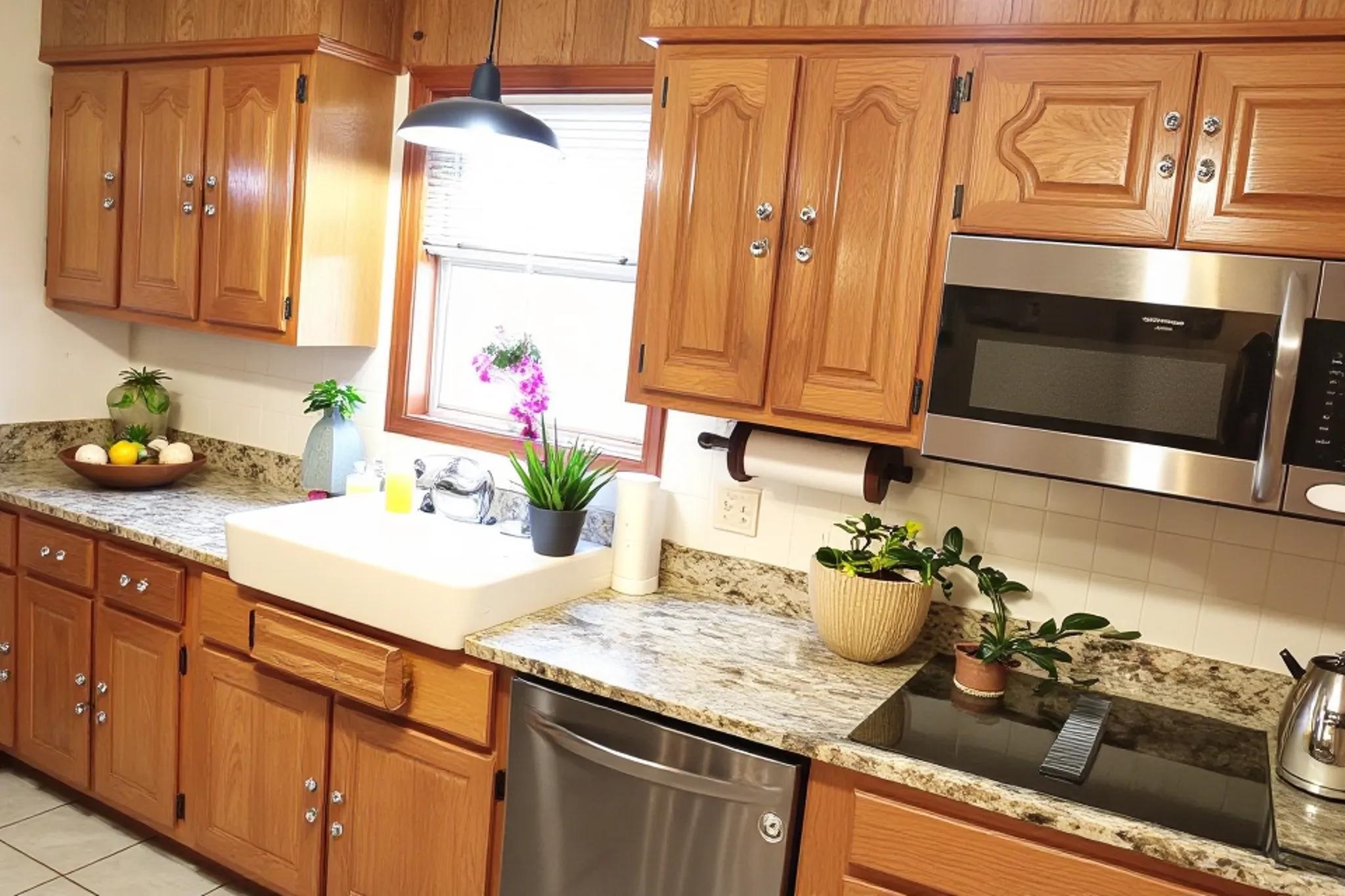 937 Kelleys Chapel Road Burlison, TN 38015 - Photo 9 of 40 Kitchen featuring wood cabinetry, solid surface countertops, an undermount sink, stainless steel appliances, and a tiled backsplash