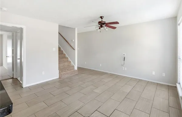 a view of a livingroom with white walls and chandelier fan