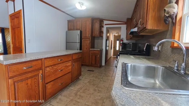 a kitchen with stainless steel appliances granite countertop a sink and a refrigerator