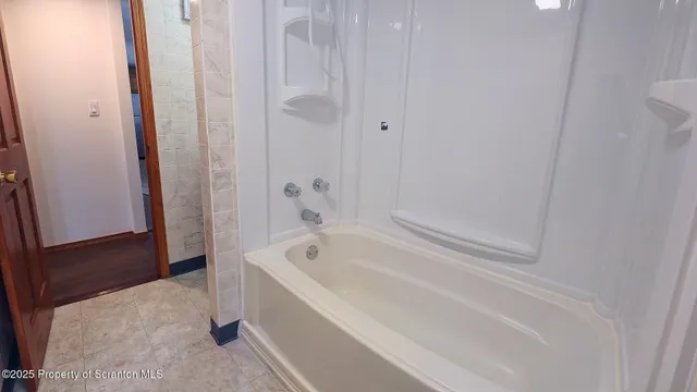 a spacious bathroom with a bathtub and shower