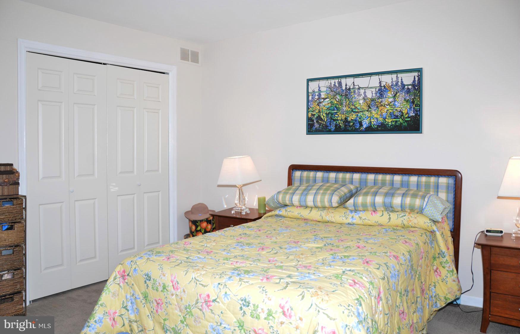 6607 Hillandale Road, Unit 89 Chevy Chase, MD 20815 - Photo 18 of 30 a bedroom with a bed and a painting on the wall