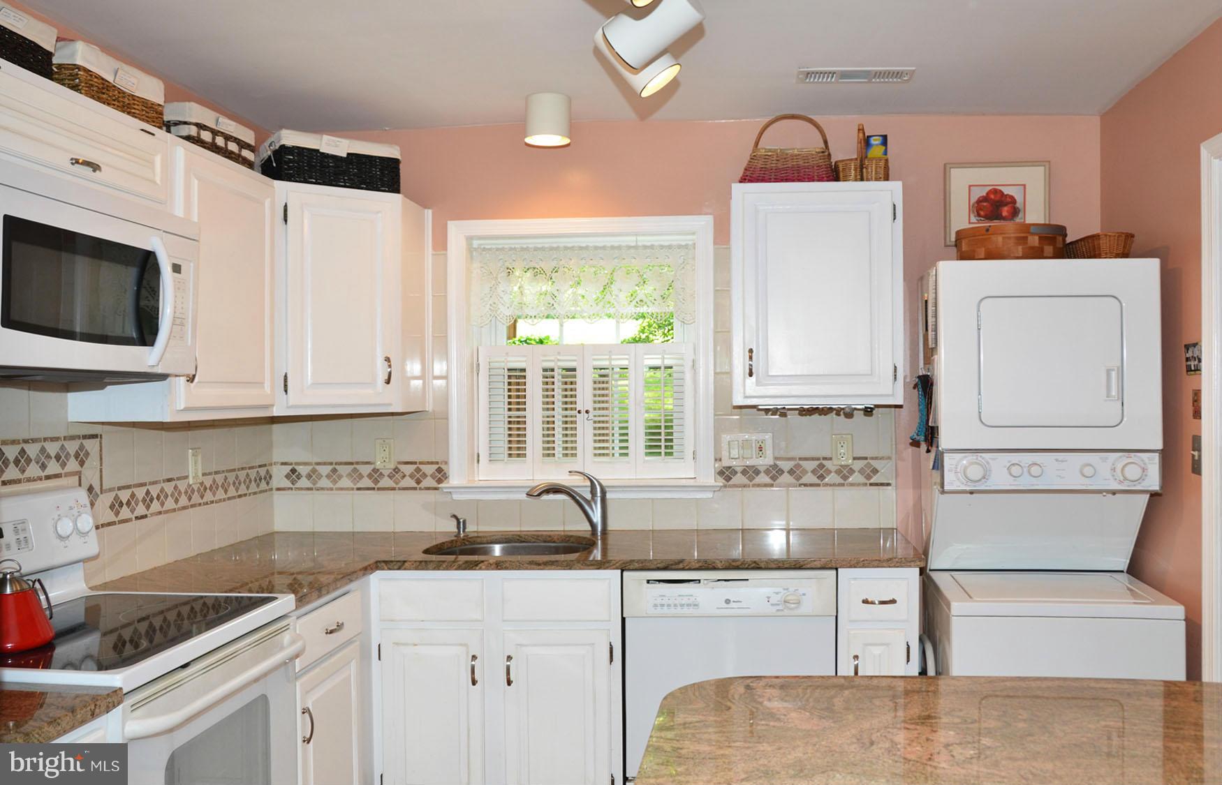 6607 Hillandale Road, Unit 89 Chevy Chase, MD 20815 - Photo 10 of 30 a kitchen with granite countertop a sink a stove and cabinets