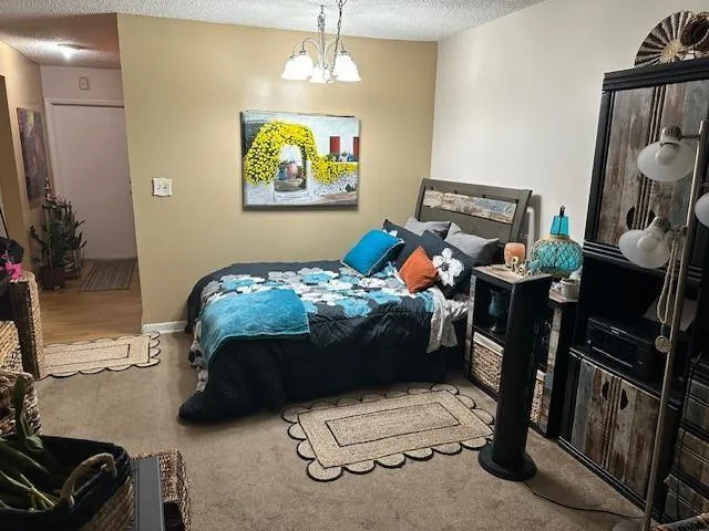 a bedroom with a bed and a chandelier