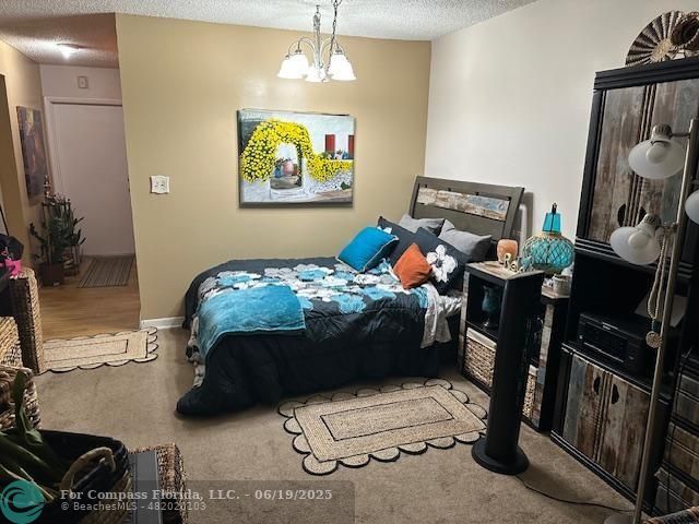 611 South State Road 7, Unit 2E Margate, FL 33068 - Photo 3 of 5 a bedroom with a bed and potted plants on the dresser