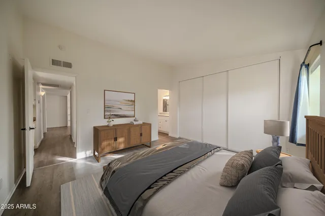 a bedroom with a bed and wooden floor