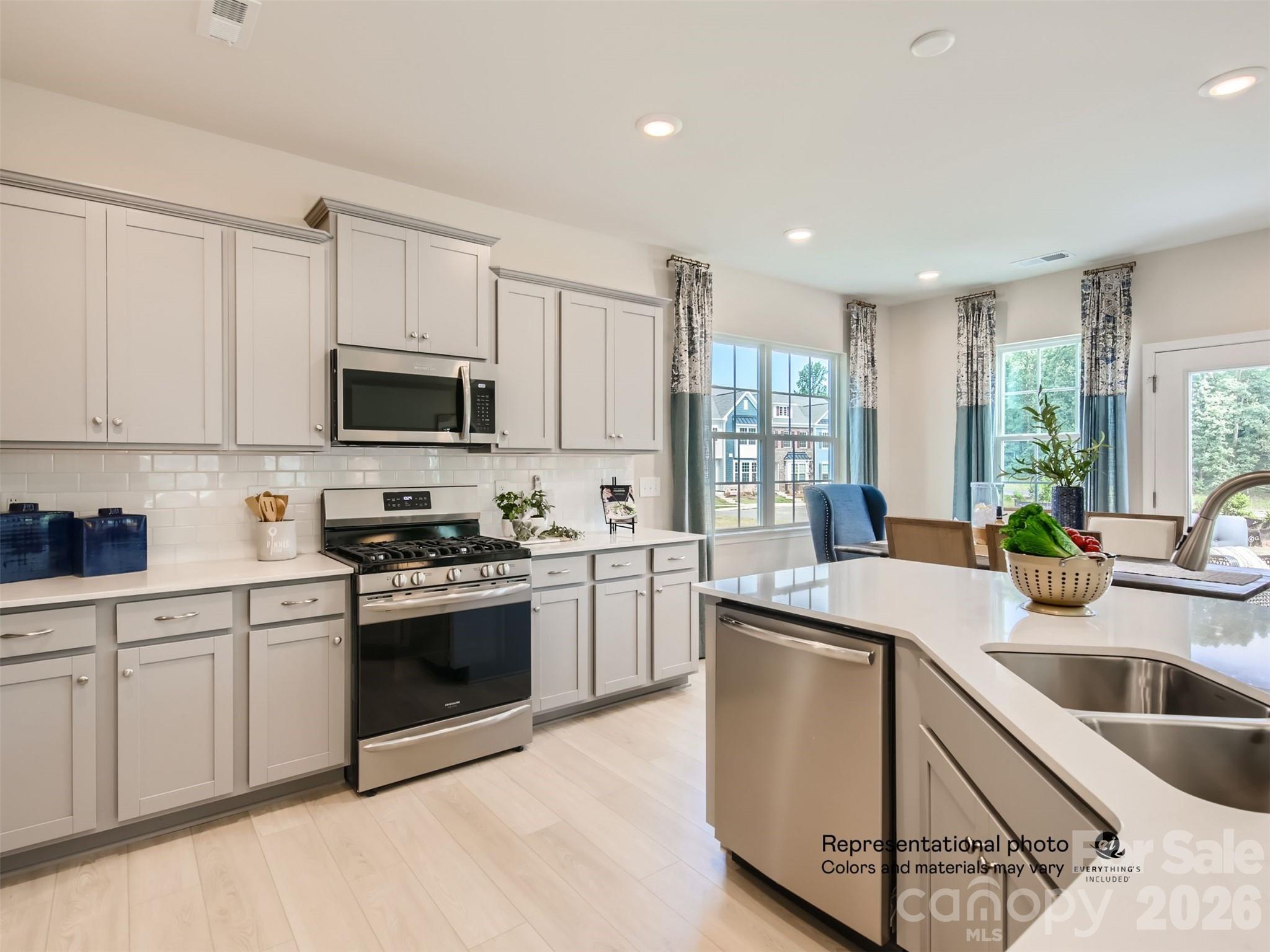 7020 Juneberry Way Maiden, NC 28650 - Photo 3 of 25 a kitchen with a sink white cabinets and stainless steel appliances