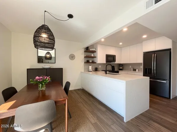 a kitchen with appliances cabinets and a wooden floor