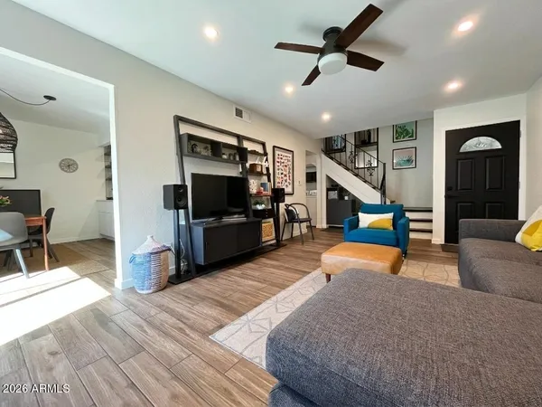 a kitchen with stainless steel appliances granite countertop a refrigerator a sink dishwasher a dining table and chairs with wooden floor