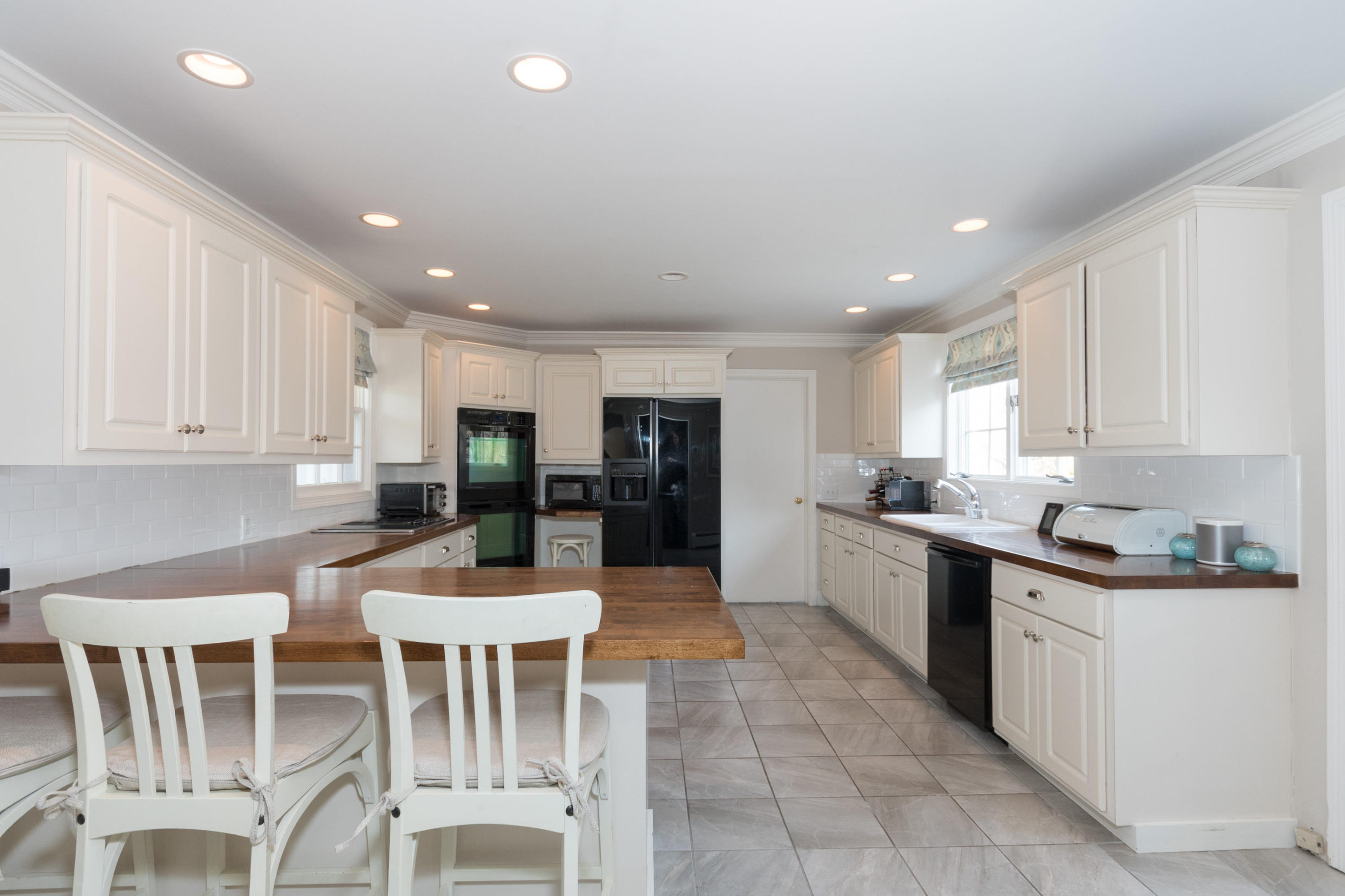 17 Point O Woods Road Darien, CT 06820 - Photo 14 of 44 a kitchen with a dining table chairs and white cabinets