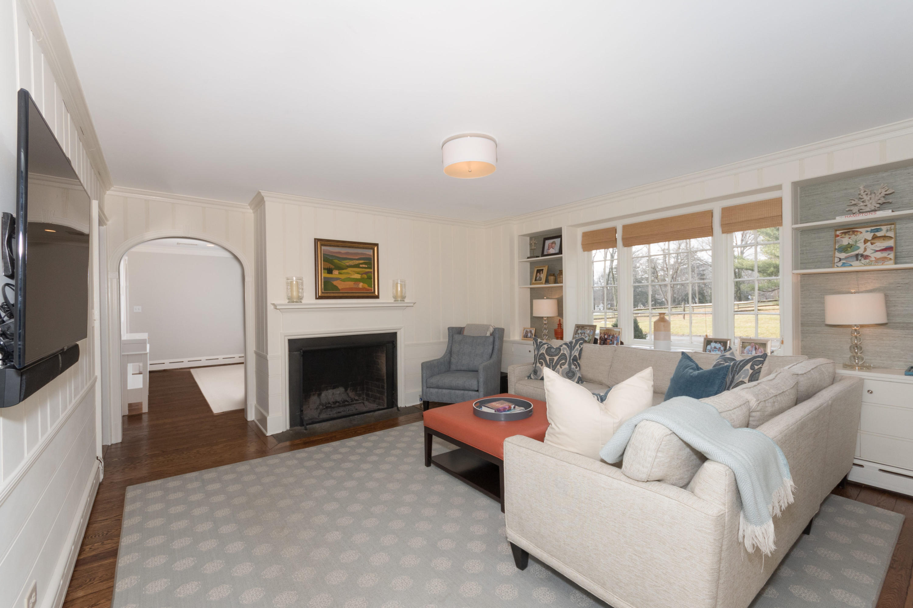 17 Point O Woods Road Darien, CT 06820 - Photo 18 of 44 a living room with furniture a fireplace and a floor to ceiling window