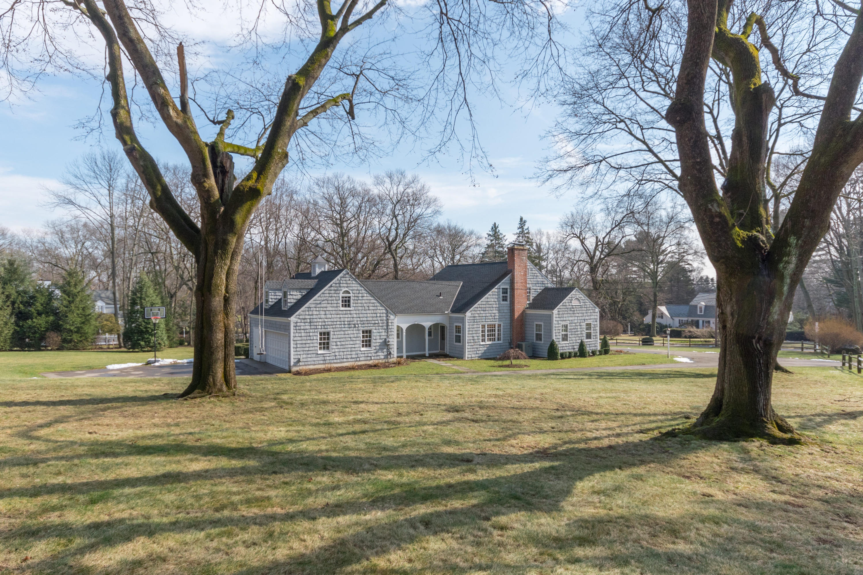 17 Point O Woods Road Darien, CT 06820 - Photo 3 of 44 a big house with large trees and a big yard
