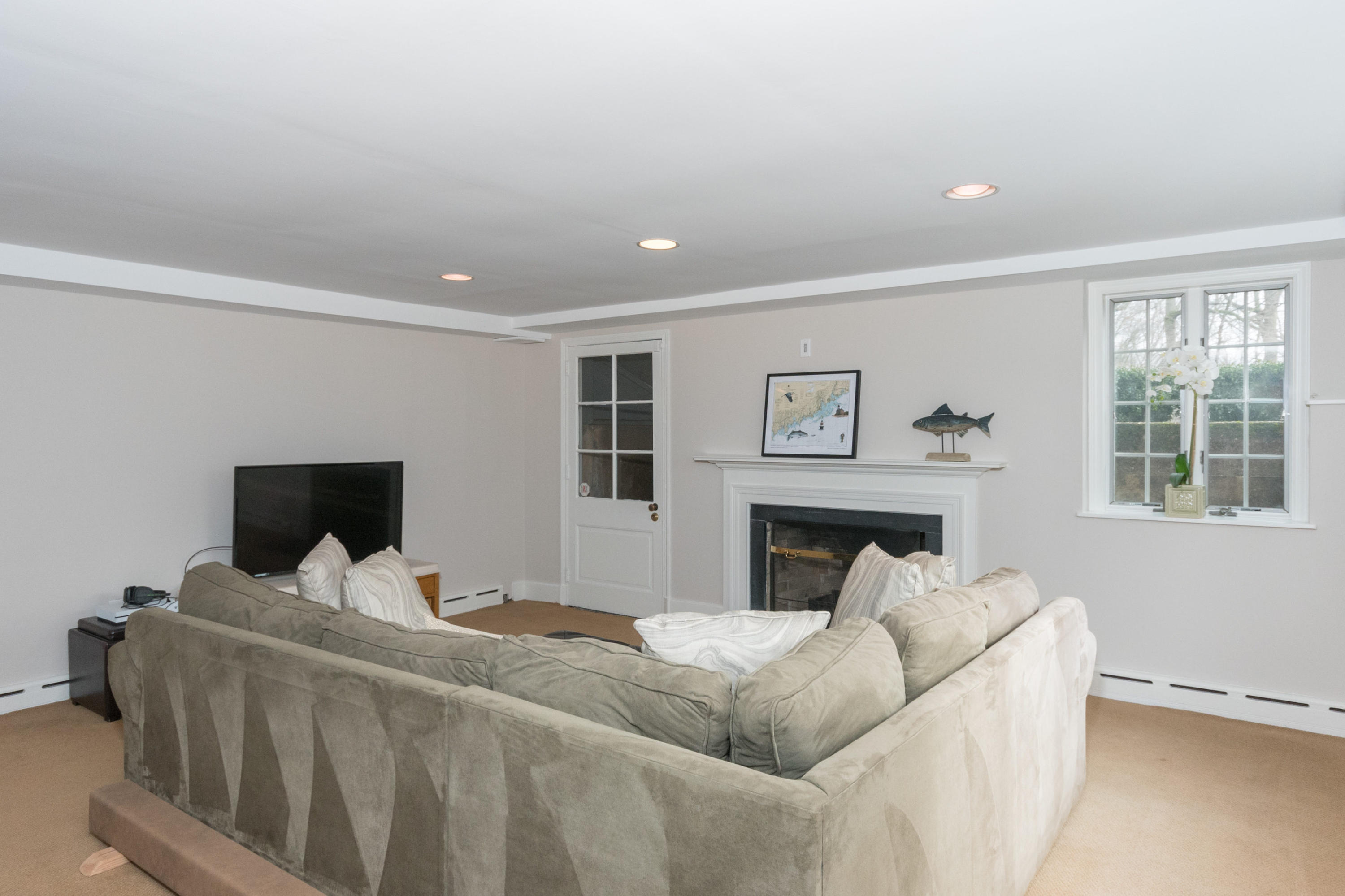 17 Point O Woods Road Darien, CT 06820 - Photo 37 of 44 a living room with furniture flat screen tv and a fireplace