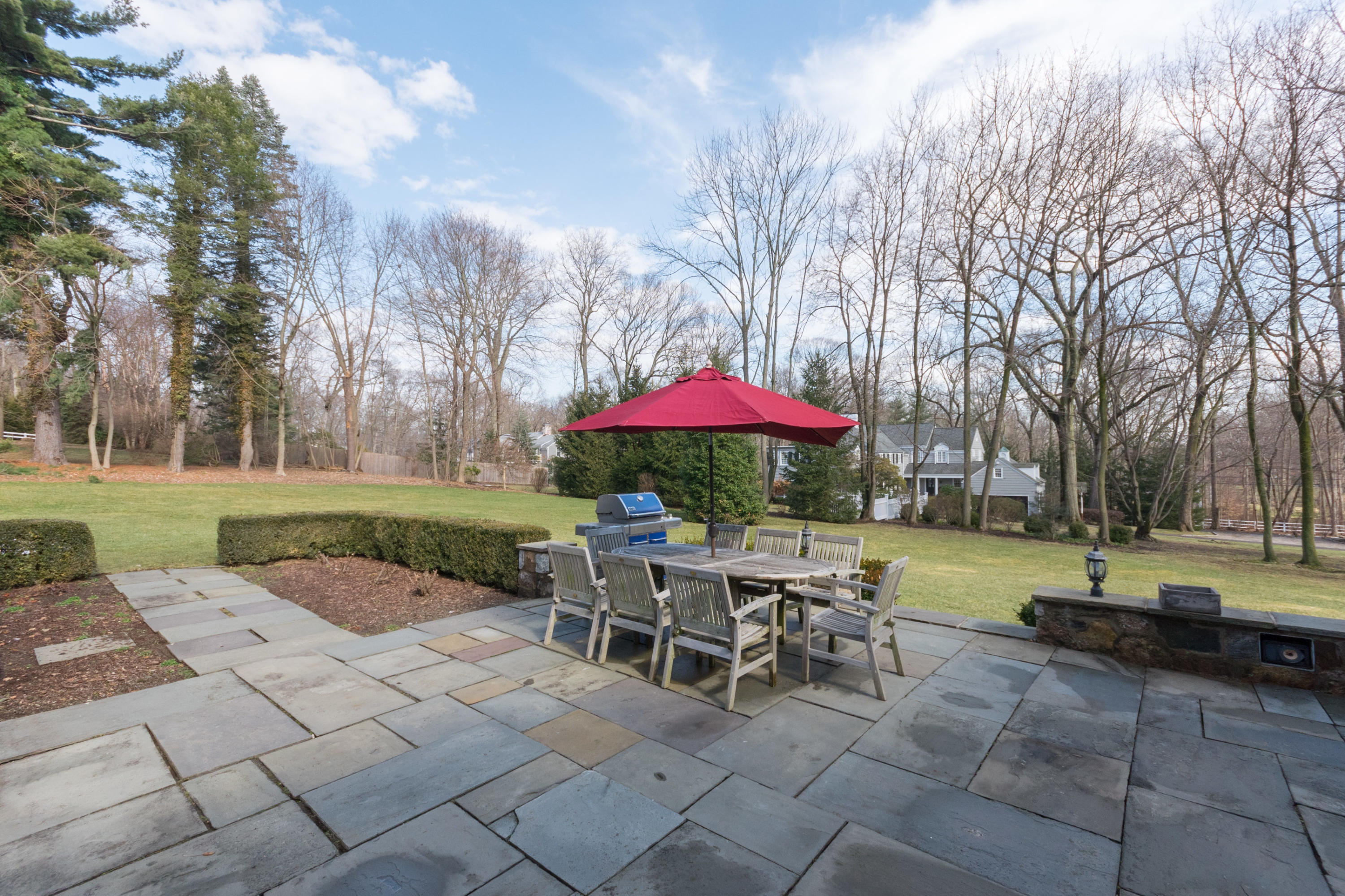 17 Point O Woods Road Darien, CT 06820 - Photo 38 of 44 a view of a backyard with table and chairs under an umbrella