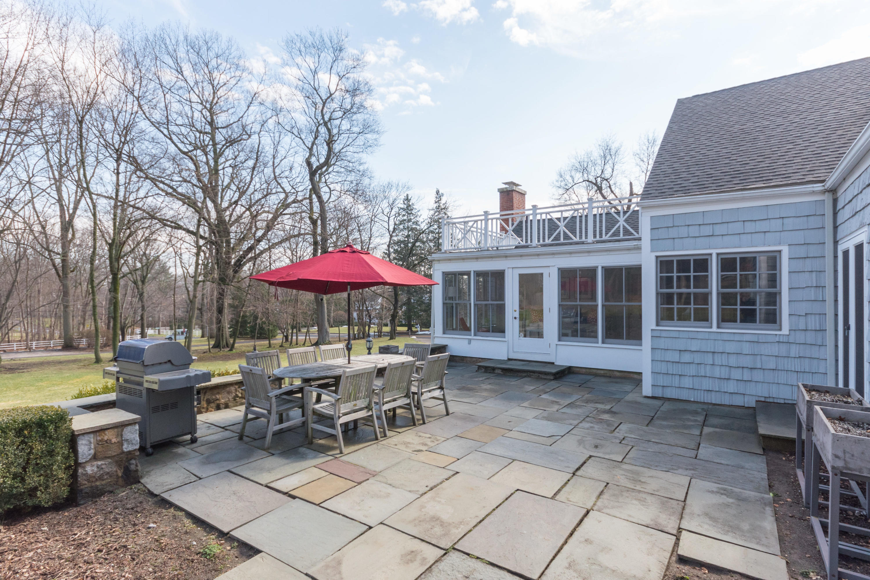 17 Point O Woods Road Darien, CT 06820 - Photo 39 of 44 a patio with a table and chairs under an umbrella