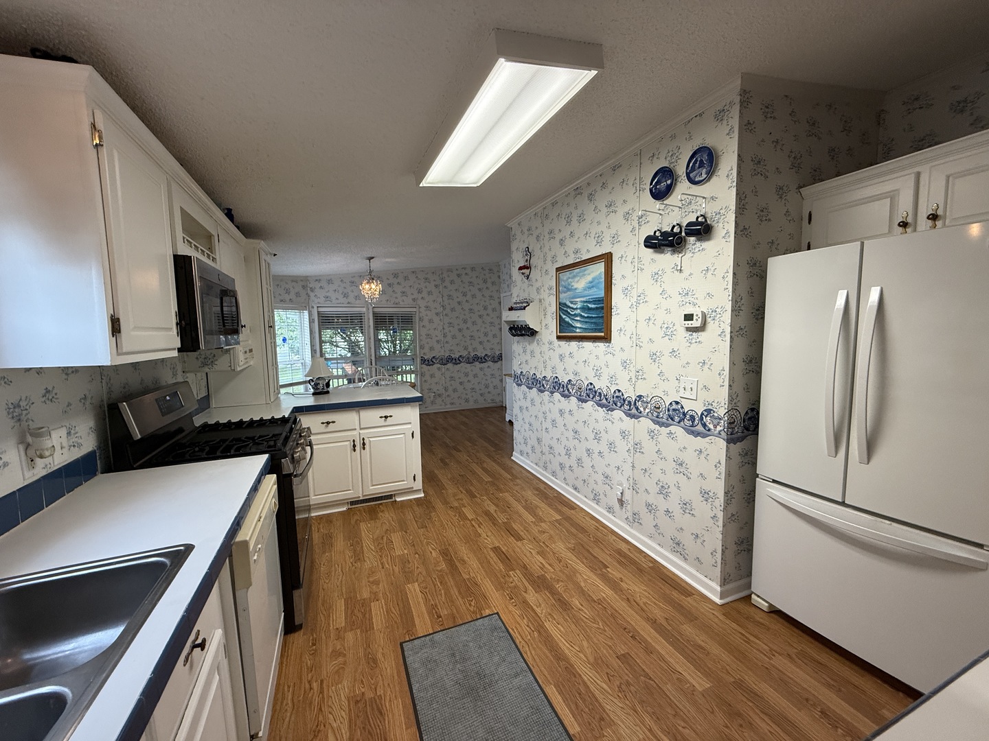 69 Petunia Circle Matteson, IL 60443 - Photo 4 of 25 a kitchen with stainless steel appliances a stove a refrigerator a sink dishwasher and wooden cabinets with wooden floor