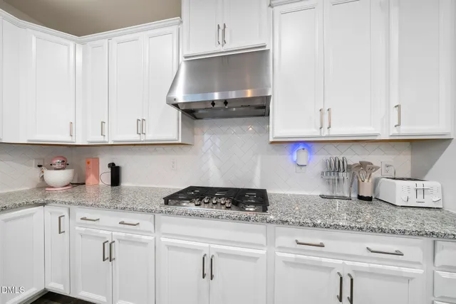 a kitchen with granite countertop stainless steel appliances a stove sink and microwave