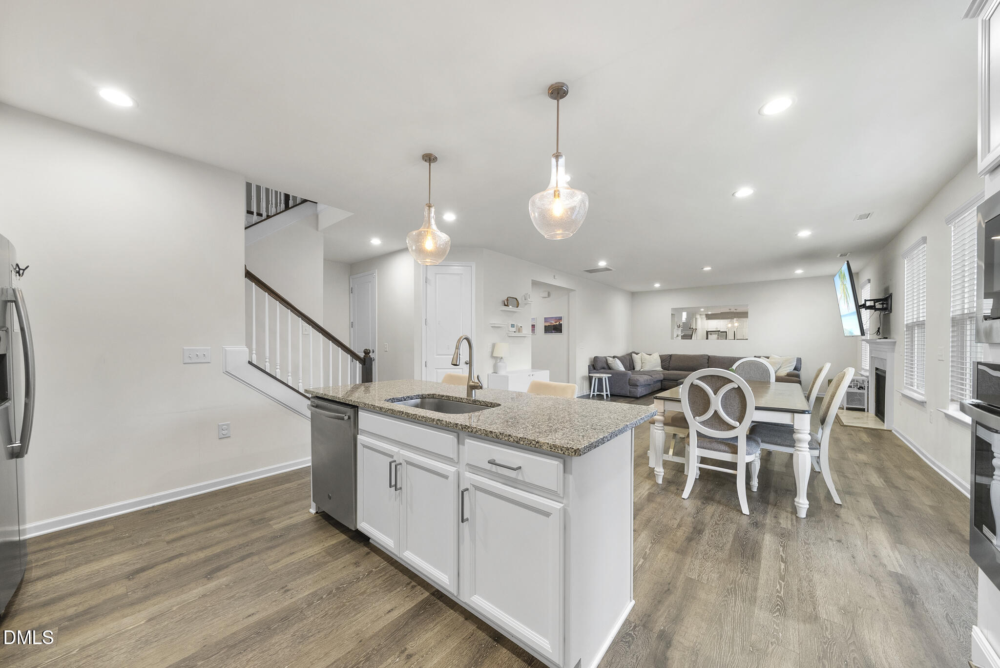 672 Millers Mark Avenue Wake Forest, NC 27587 - Photo 13 of 41 a kitchen with stainless steel appliances kitchen island granite countertop a table chairs and a wooden floor