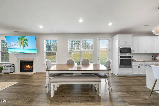a living room with furniture and a flat screen tv with kitchen view