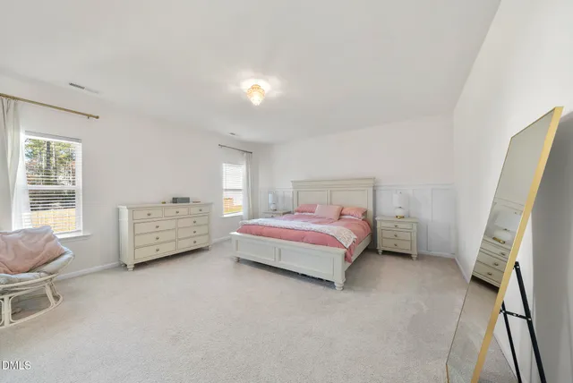 a bedroom with a bed and a chandelier fan