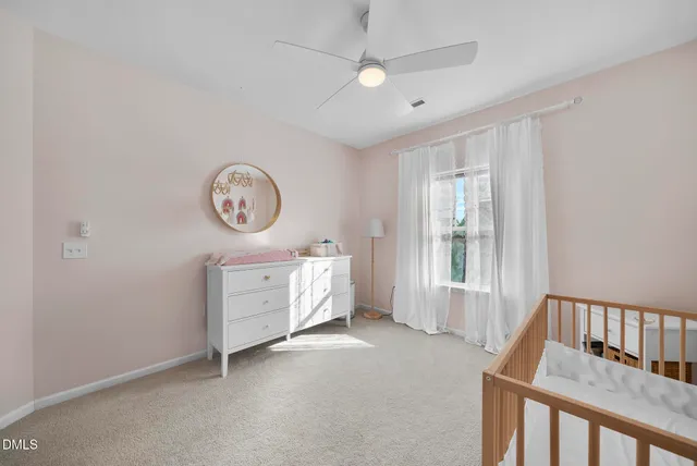a bedroom with a baby bed a chandelier and a window