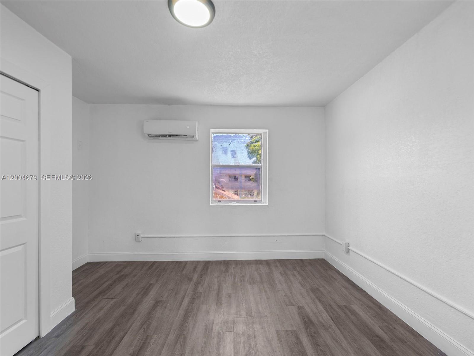 500 Southwest 8th Street Miami, FL 33130 - Photo 12 of 33 a view of an empty room with wooden floor and a window
