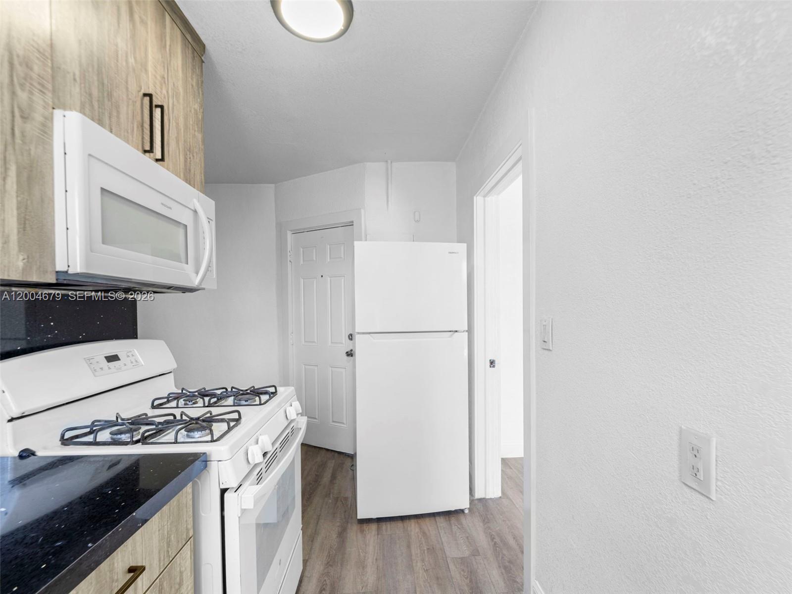 500 Southwest 8th Street Miami, FL 33130 - Photo 20 of 33 a kitchen with a stove a refrigerator and a cabinets