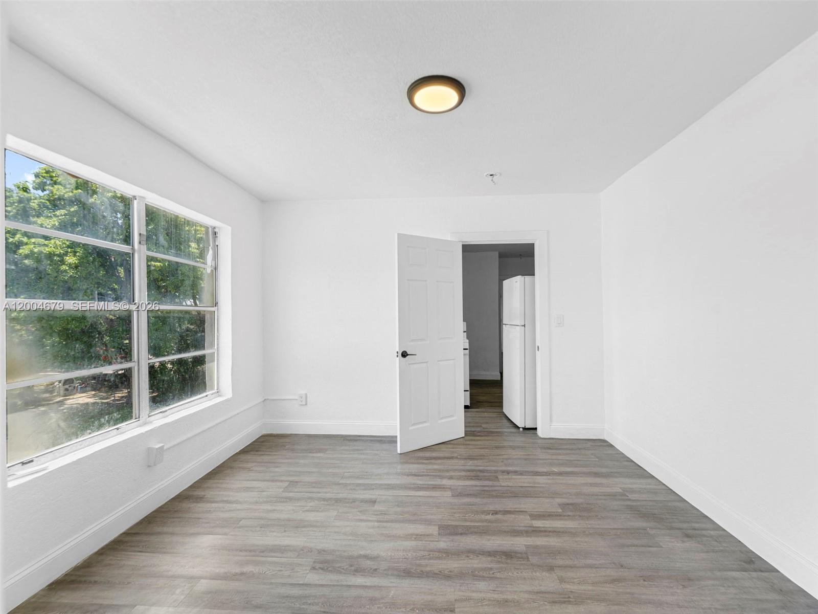 500 Southwest 8th Street Miami, FL 33130 - Photo 22 of 33 a view of an empty room with wooden floor and a window